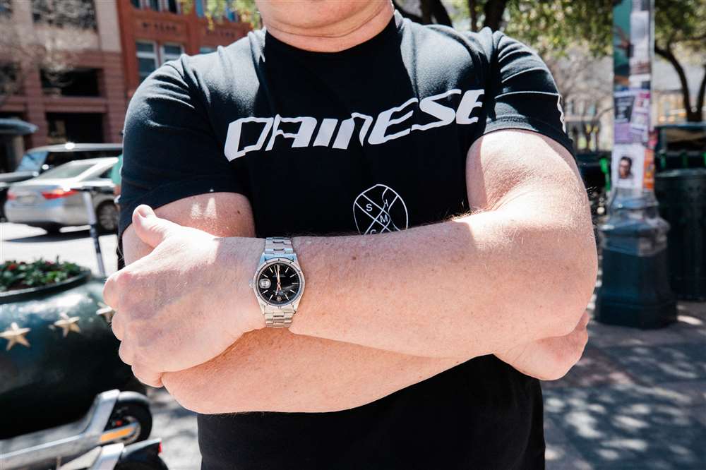佩戴勞力士手表的雙臂交叉的人。